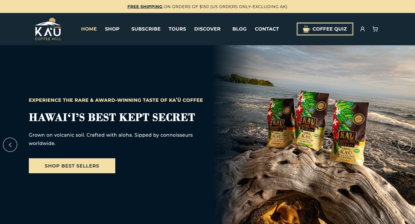 Kaʻū Coffee Mill storefront hero showing three bags of Hawaiʻi-grown estate coffee on driftwood above the ocean